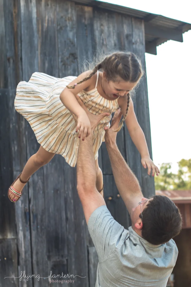 father throwing daughter into air