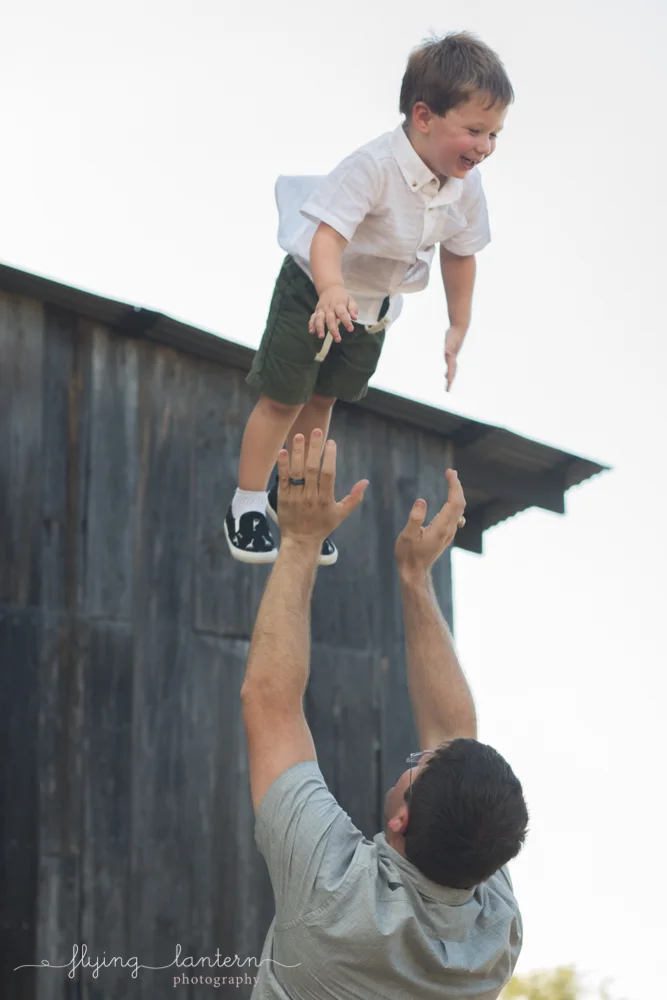 father throwing son into air