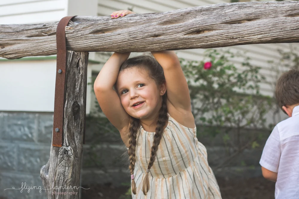 four year old girl holding onto branch
