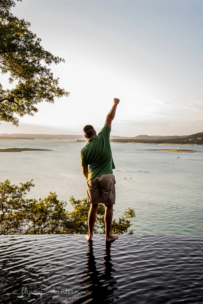Extended family session on Lake Travis during family reunion. male portrait punching sky in victory. Photo by Erin Reas of Flying Lantern Photography