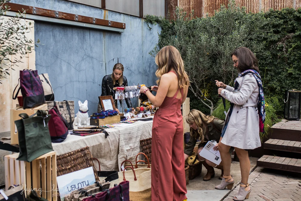 Girls looking at handmade goods at Ubuntu Life gala at the Pershing. Event Photography by Erin Reas of Flying Lantern Photography