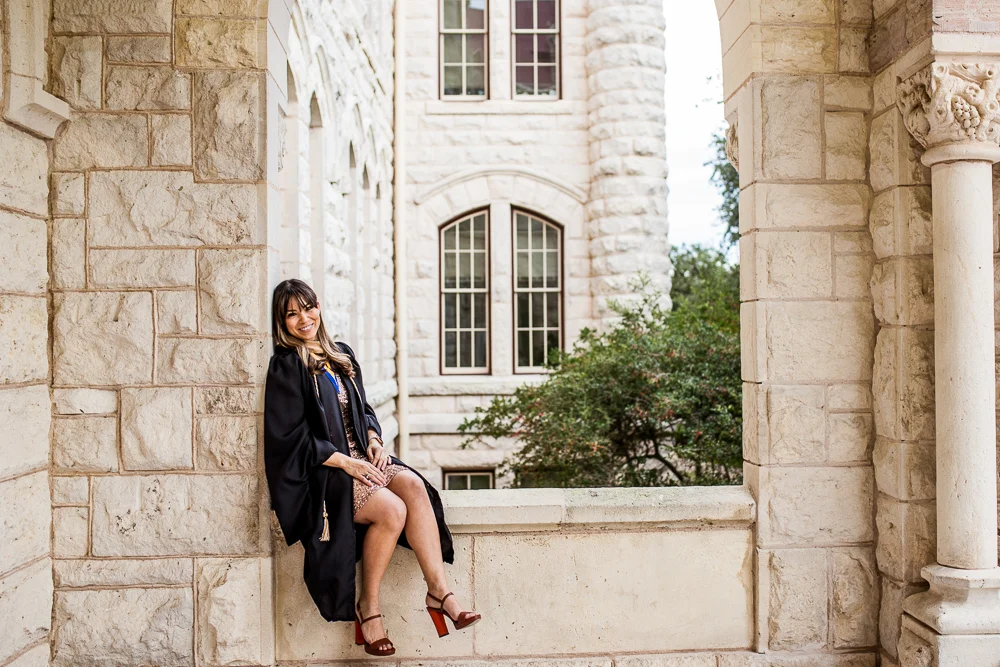 Graduate student at St. Edward’s University in Austin, TX posing at main building ledge. Senior portrait by Erin Reas of Flying Lantern Photography.