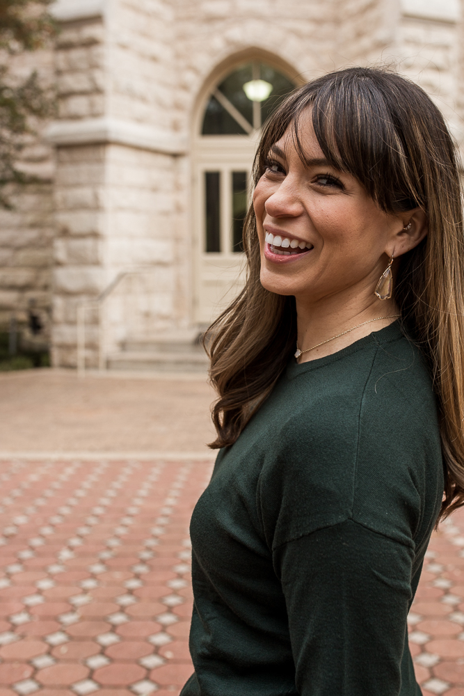 Graduation portrait of girl wearing green sweater at St. Edward’s University portrait by Erin Reas of Flying Lantern Photography