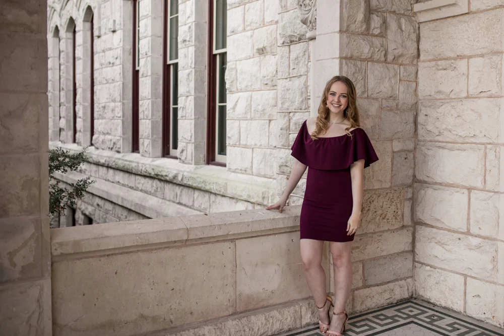 Senior portrait of girl at St. Edward’s University at Main Building wearing purple dress. Photo by Erin Reas Austin, TX photographer
