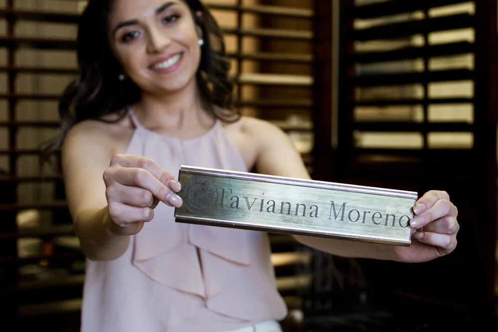 college graduate senior portrait in texas state capitol building. inside her office sitting next to window. photo by erin reas austin photographer