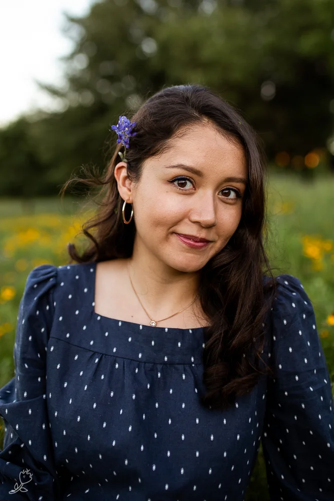 Senior lifestyle portrait sitting in a field of flowers. Photo by Erin Reas college senior photographer in Austin, TX