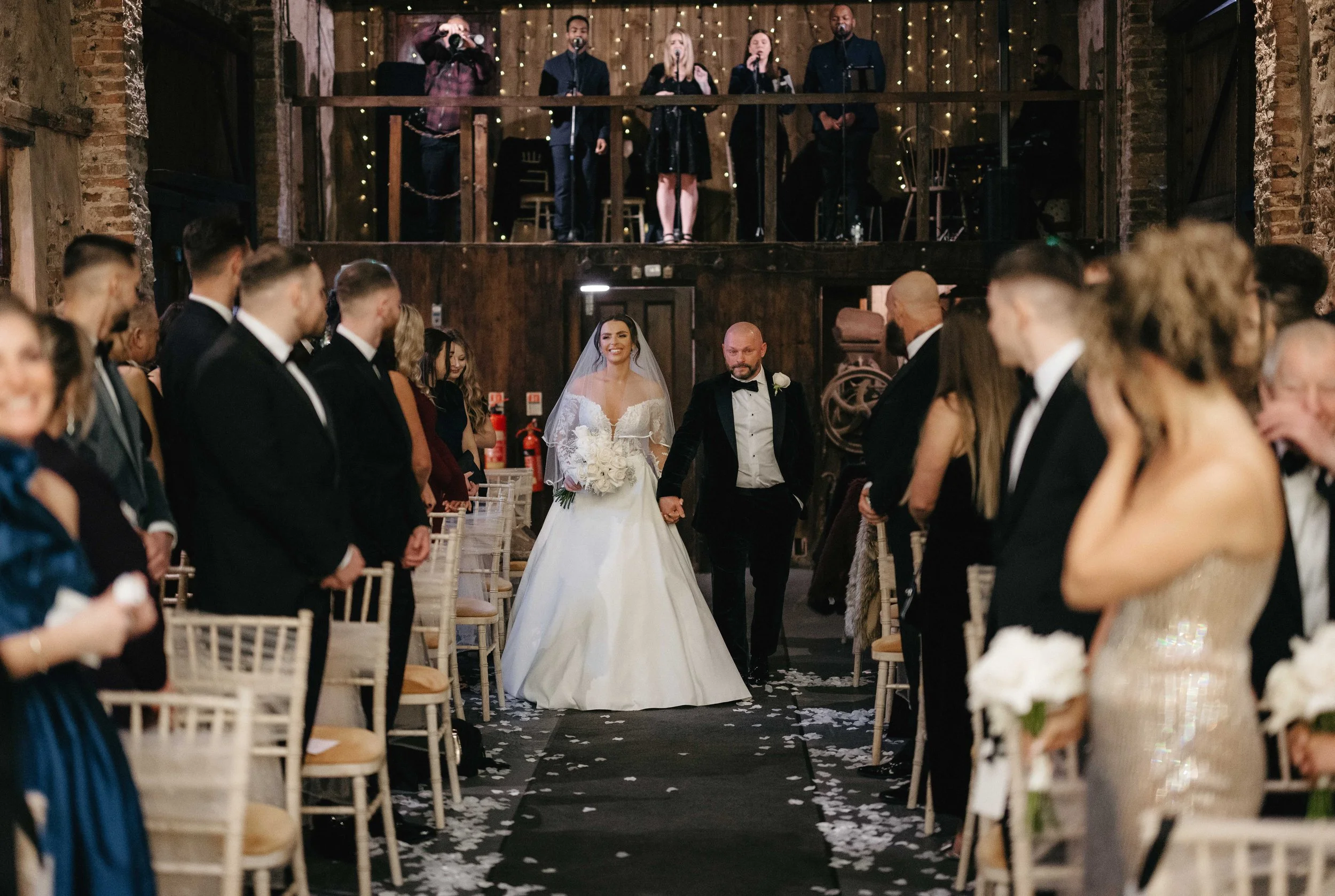 Bride and her dad walk down the aisle in The Normans rustic Ceremony Barn. Photo by Razor Blade