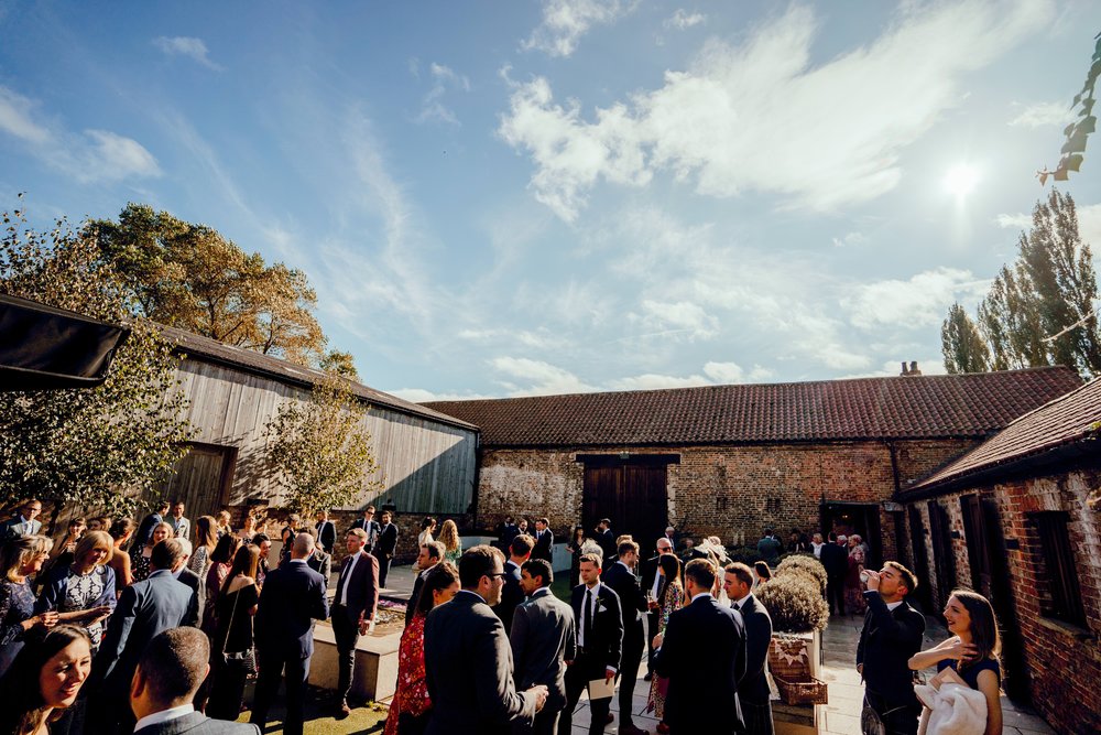 Wedding guests The Normans wedding venue Courtyard. Hamish Irvine.jpg