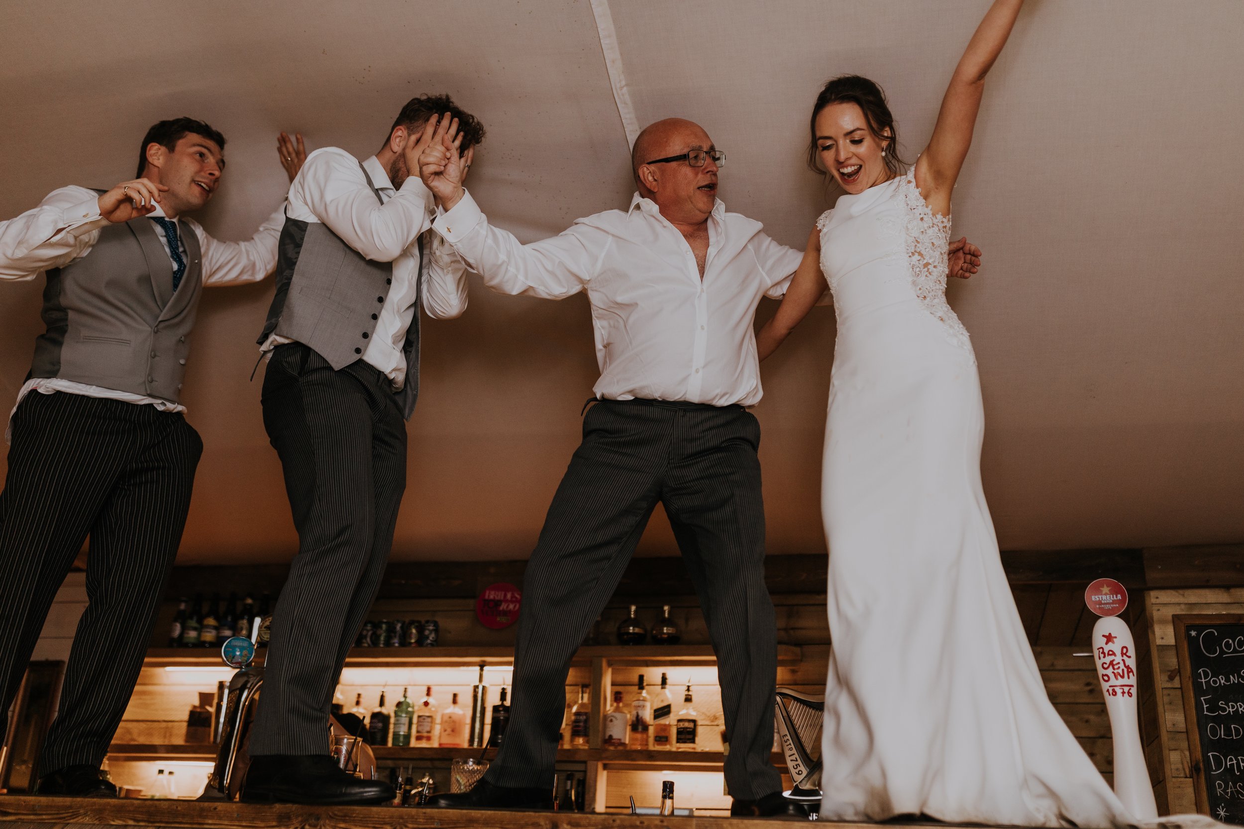 Father of the bride and Bride Maria bust moves on the bar at The Normans wedding venue. Photo by Louise Anna Photography.jpg