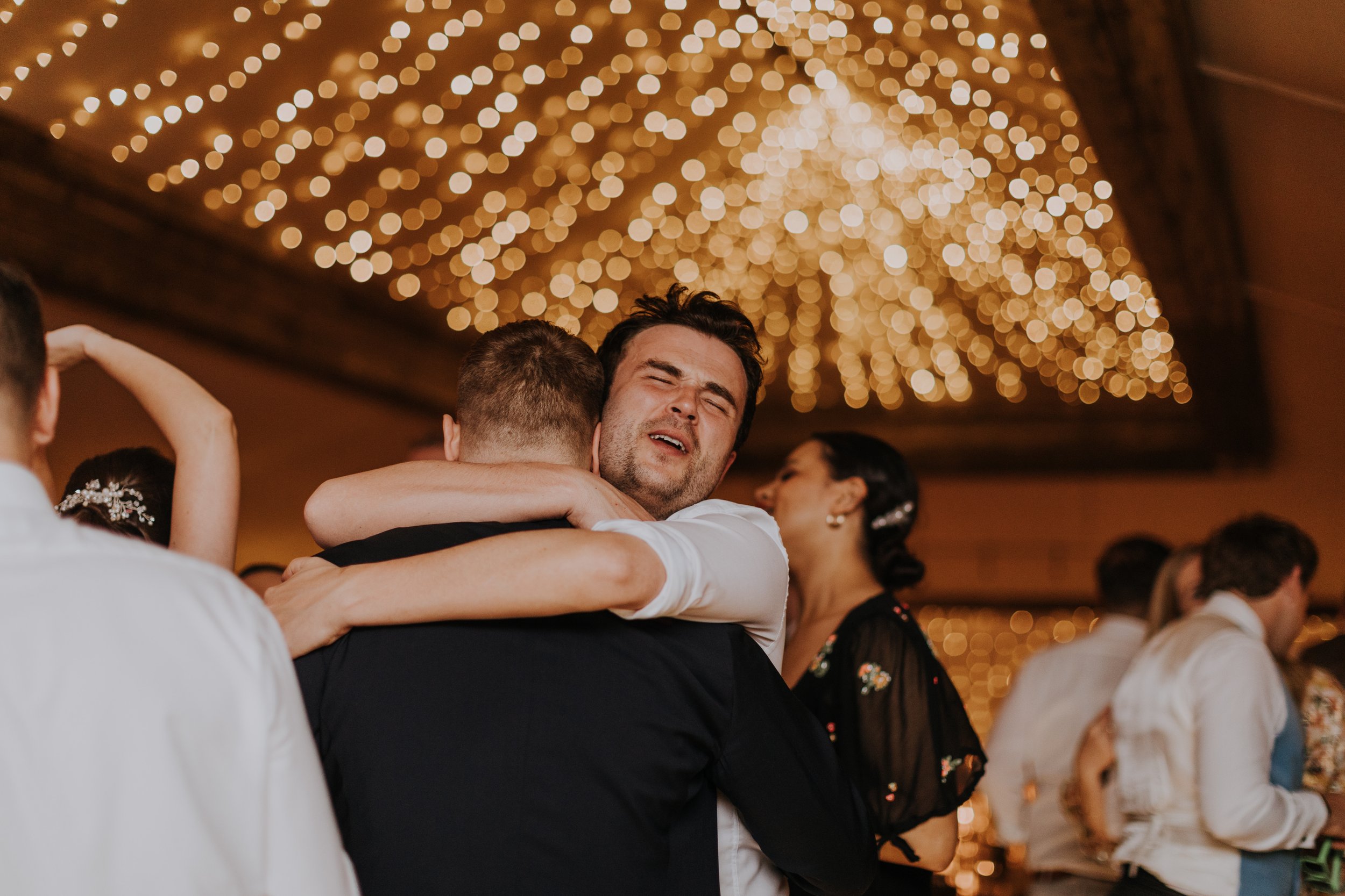 Man hugs on The Normans wedding venue dance floor. Photo by Louise Anna Photography.jpg