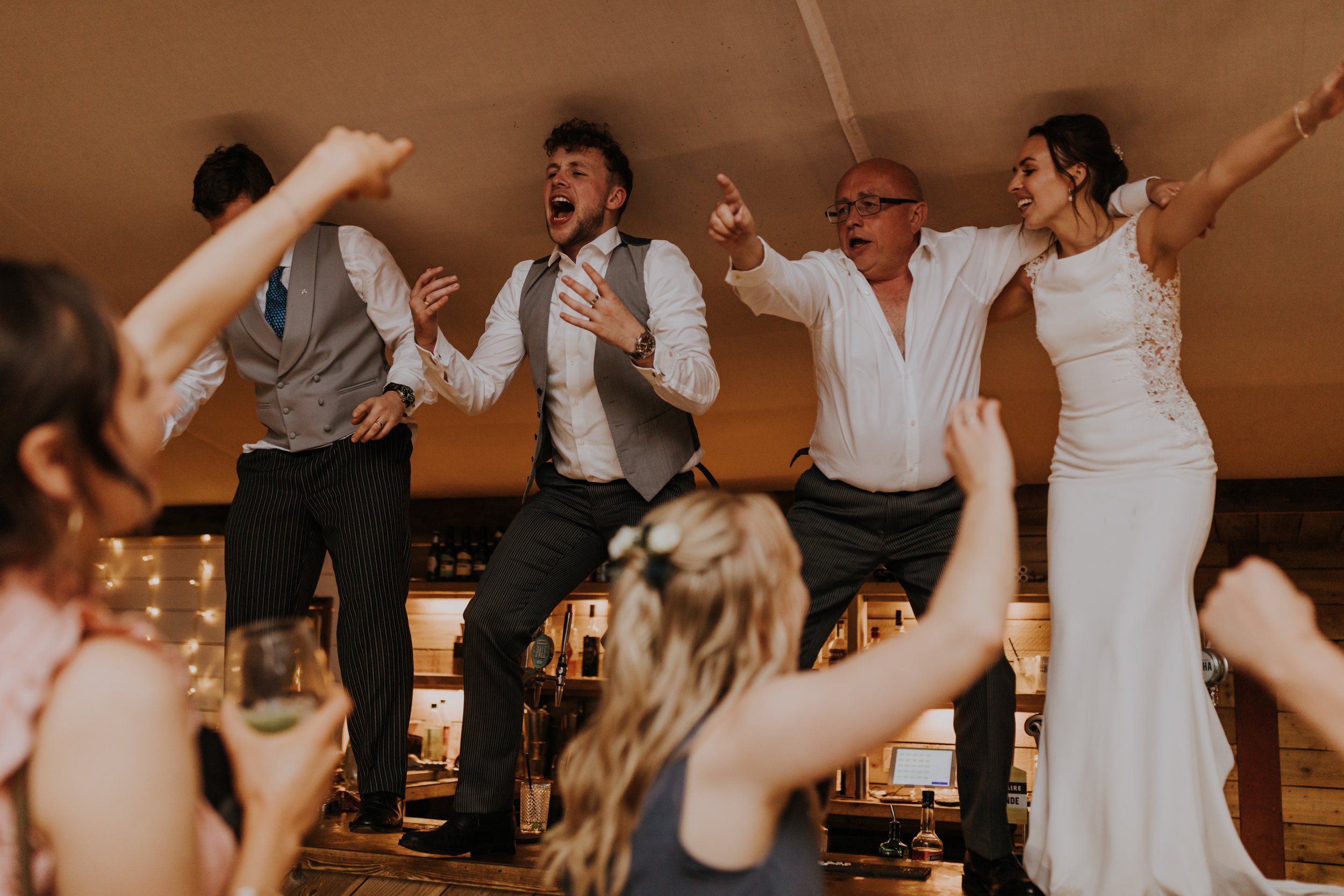 Bride dances on the bar at The Normans wedding venue. Photo by Louise Anna Photography.jpg