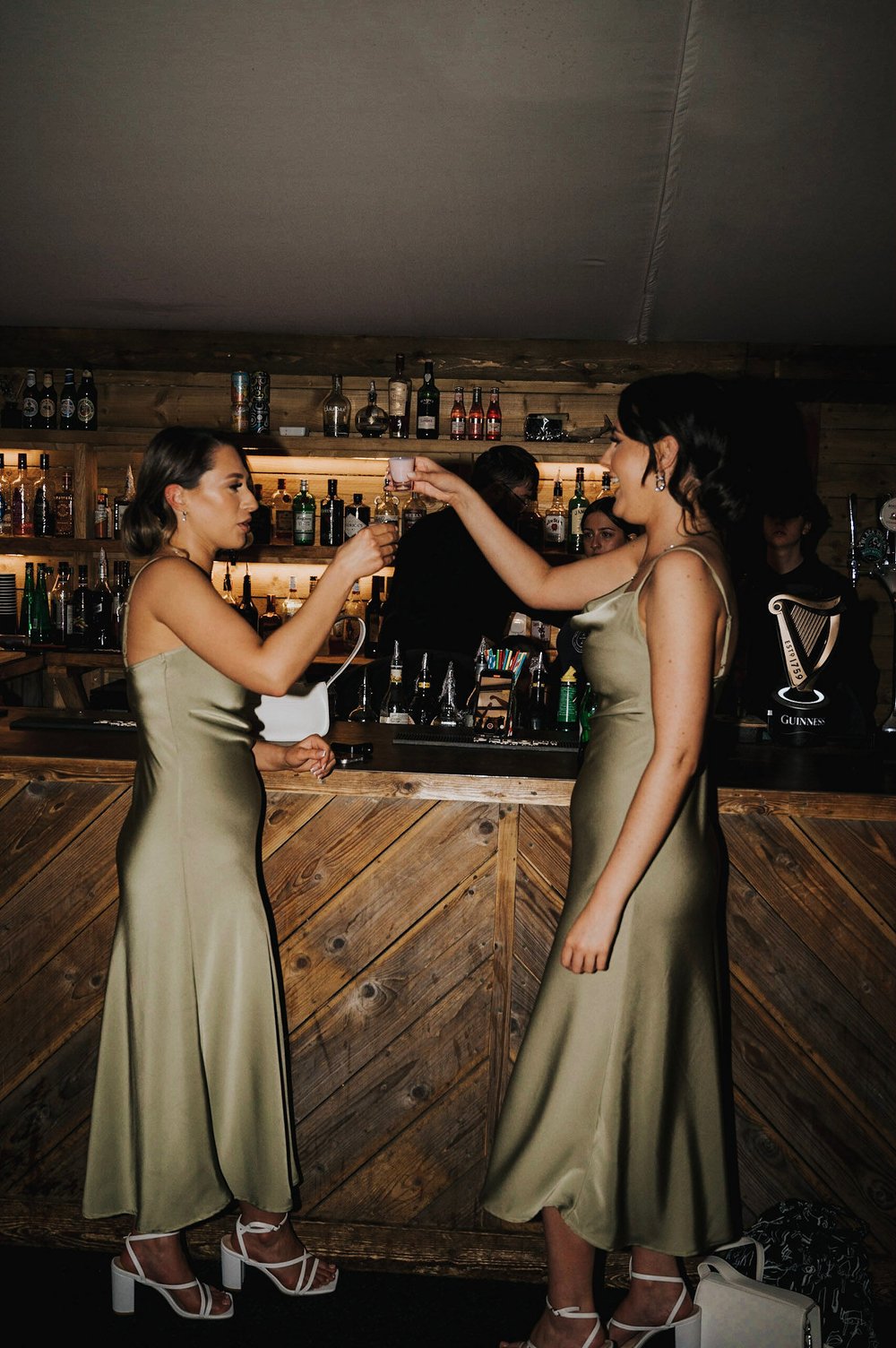 08_Bridesmaids do shots at the bar at The Normans wedding venue. Photo Charlotte White.jpg