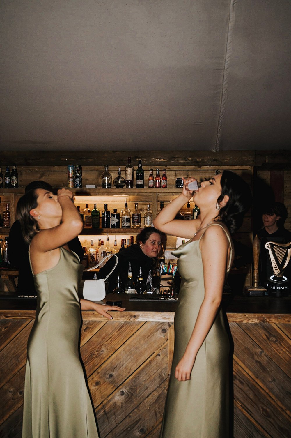 08_Bridesmaids do shots at the bar at The Normans wedding venue. Photo Charlotte White (2).jpg