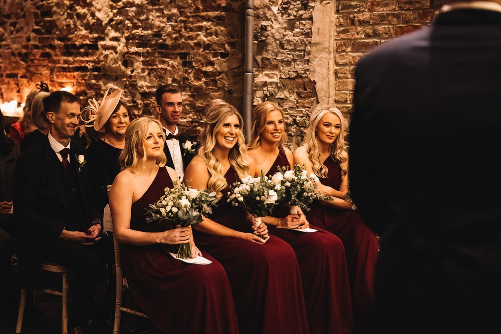 16_Bridesmaids in The Normans wedding venue ceremony barn. Photo by Lumiere Photographic.jpg