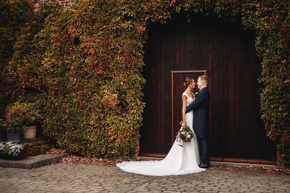 24_Bride and groom in farmhouse courtyard at The Normans wedding veue. Photo by Lumiere Photographic.jpg