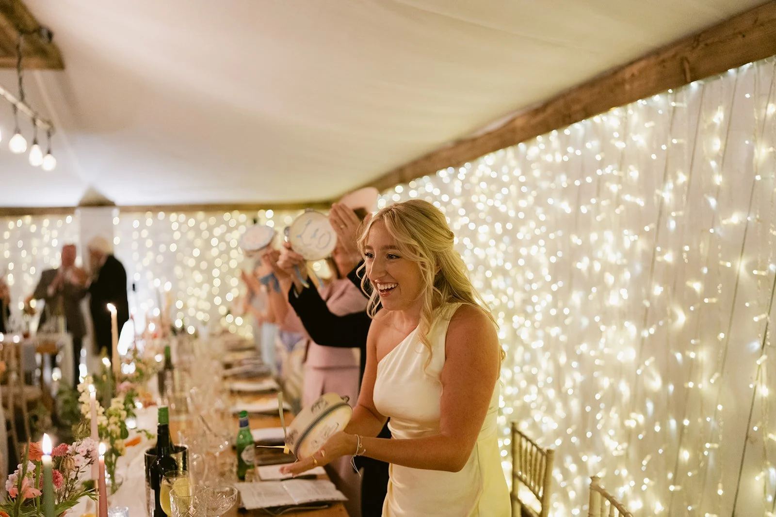 bridesmaid-top-table-tambourine-fairy-light-wall.jpg