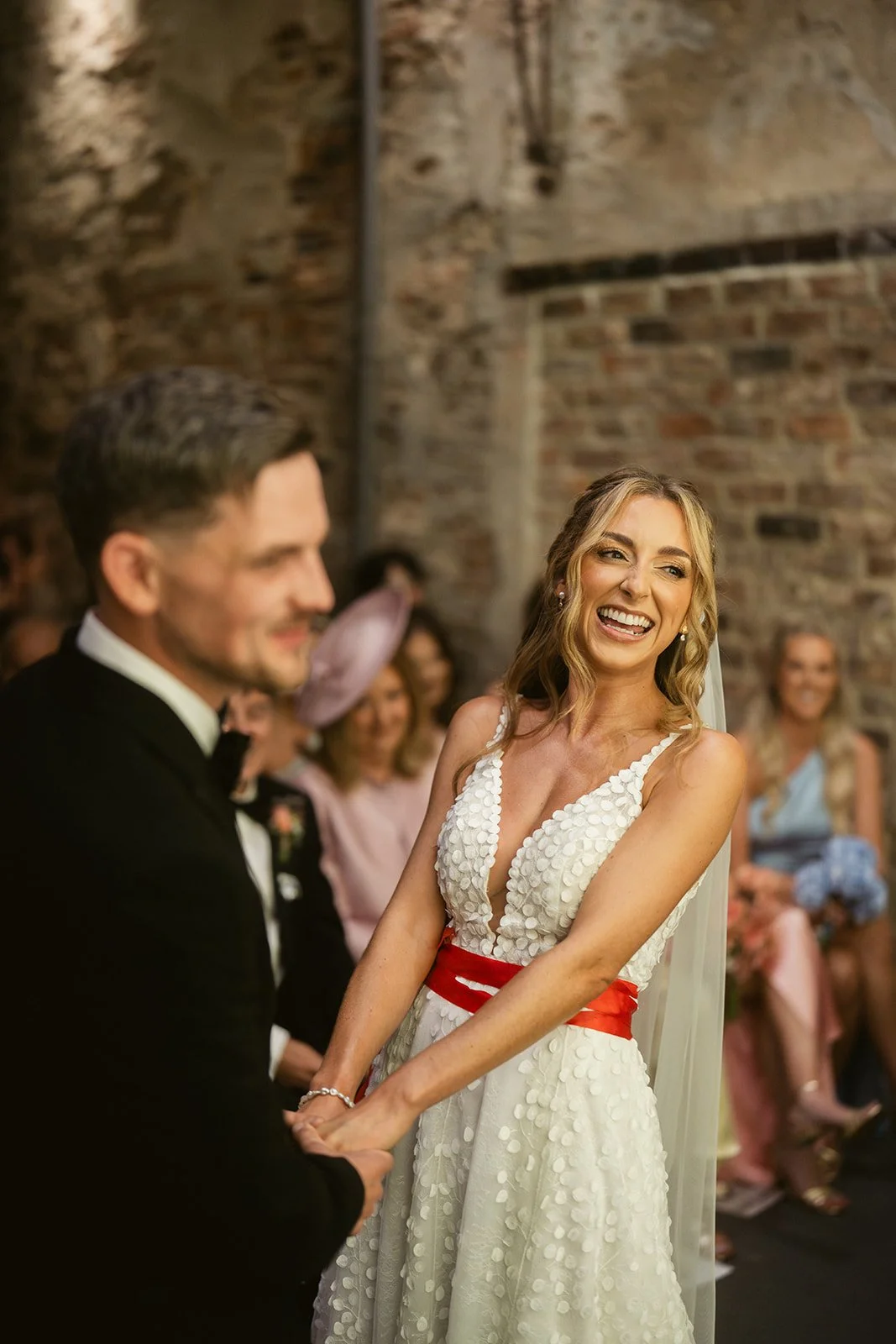 laughing-bride-red-ribbon-sash-ceremony.jpg
