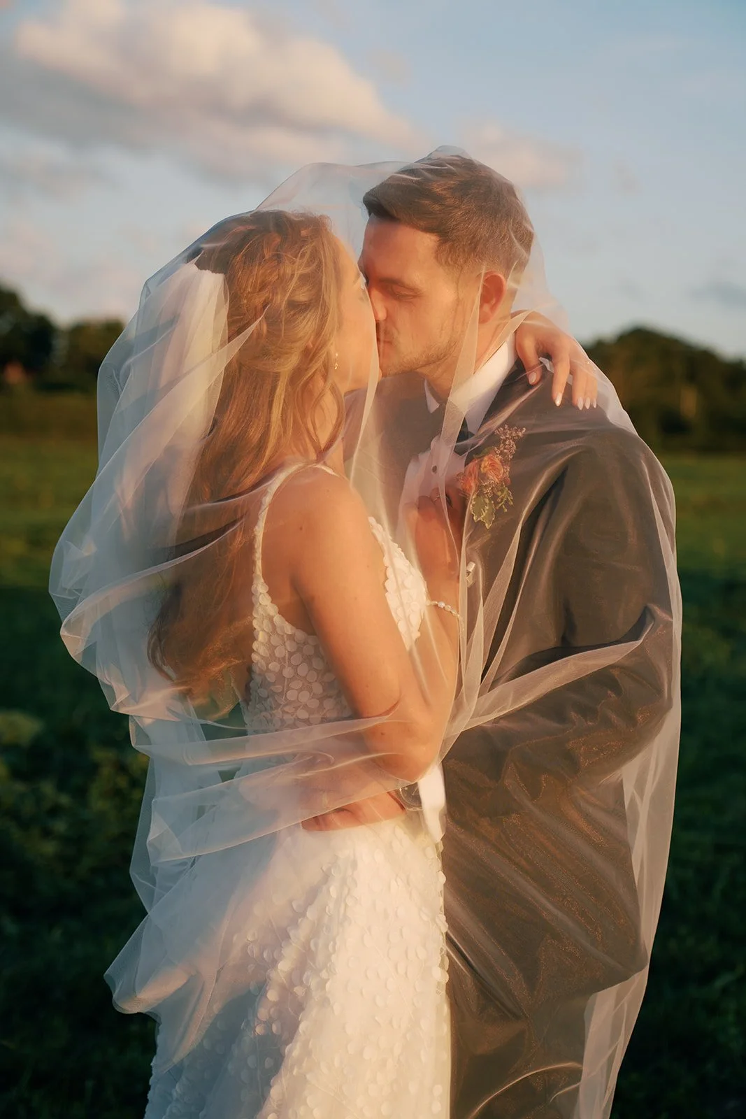 bride-groom-kiss-under-veil-golden-hour.jpg