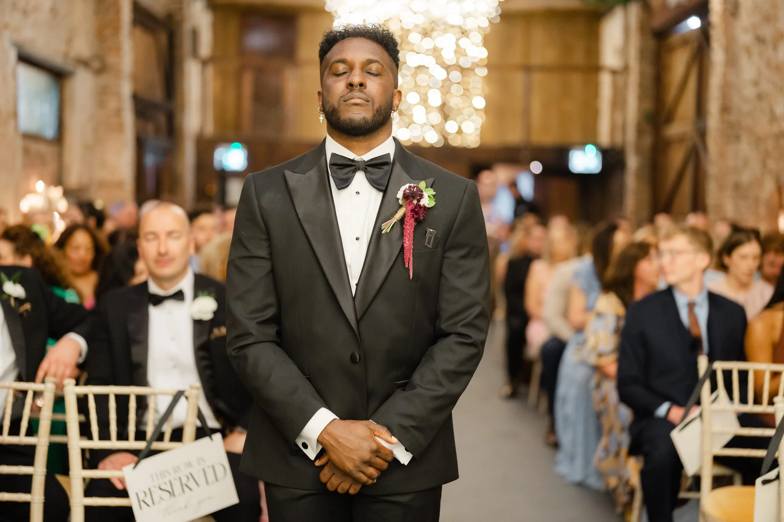 the-normans-groom-waiting-aisle-fairy-lights-ceremony-barn-268.jpg