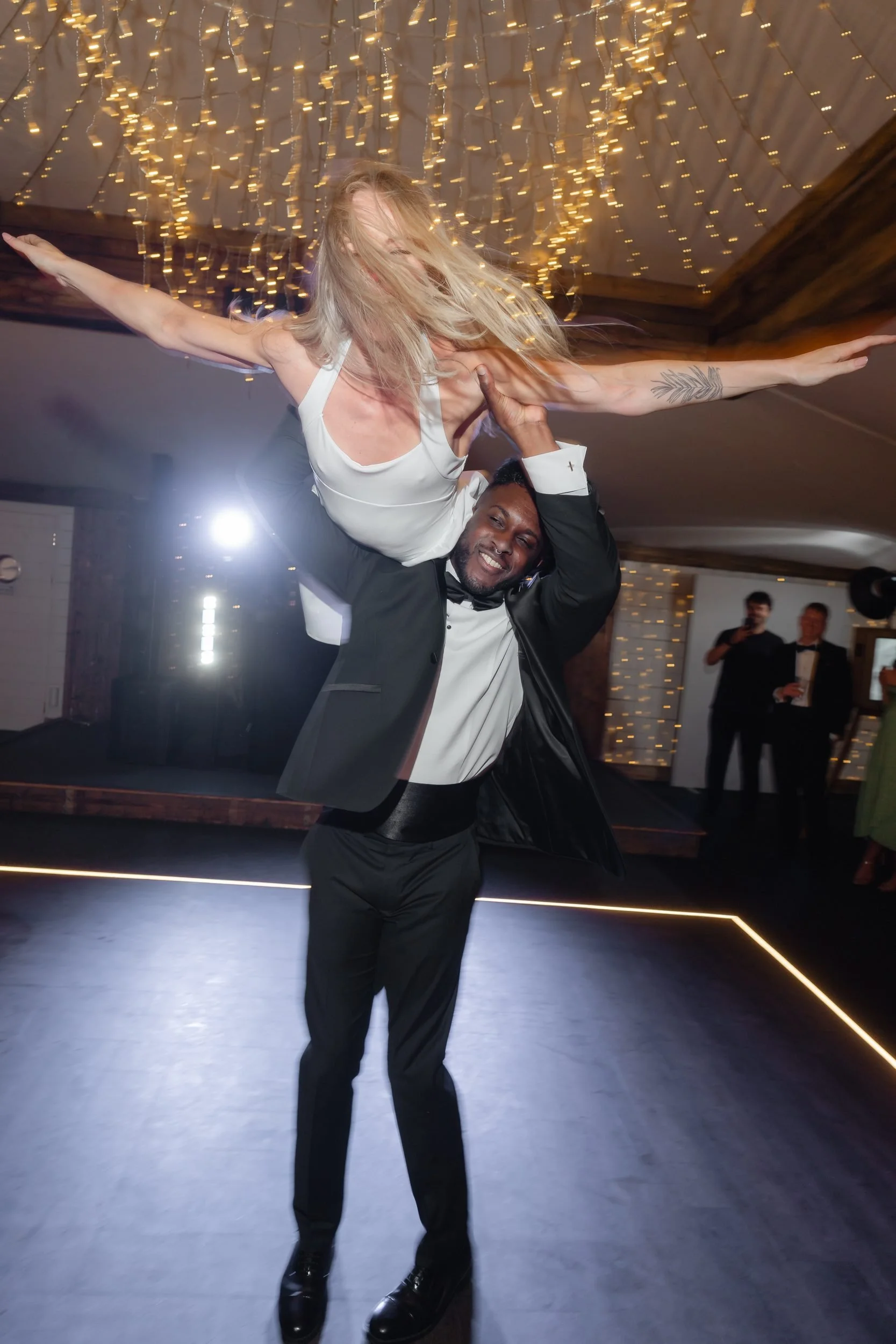 the-normans-bride-on-groom-shoulders-first-dance-fairy-lights-1029.jpg