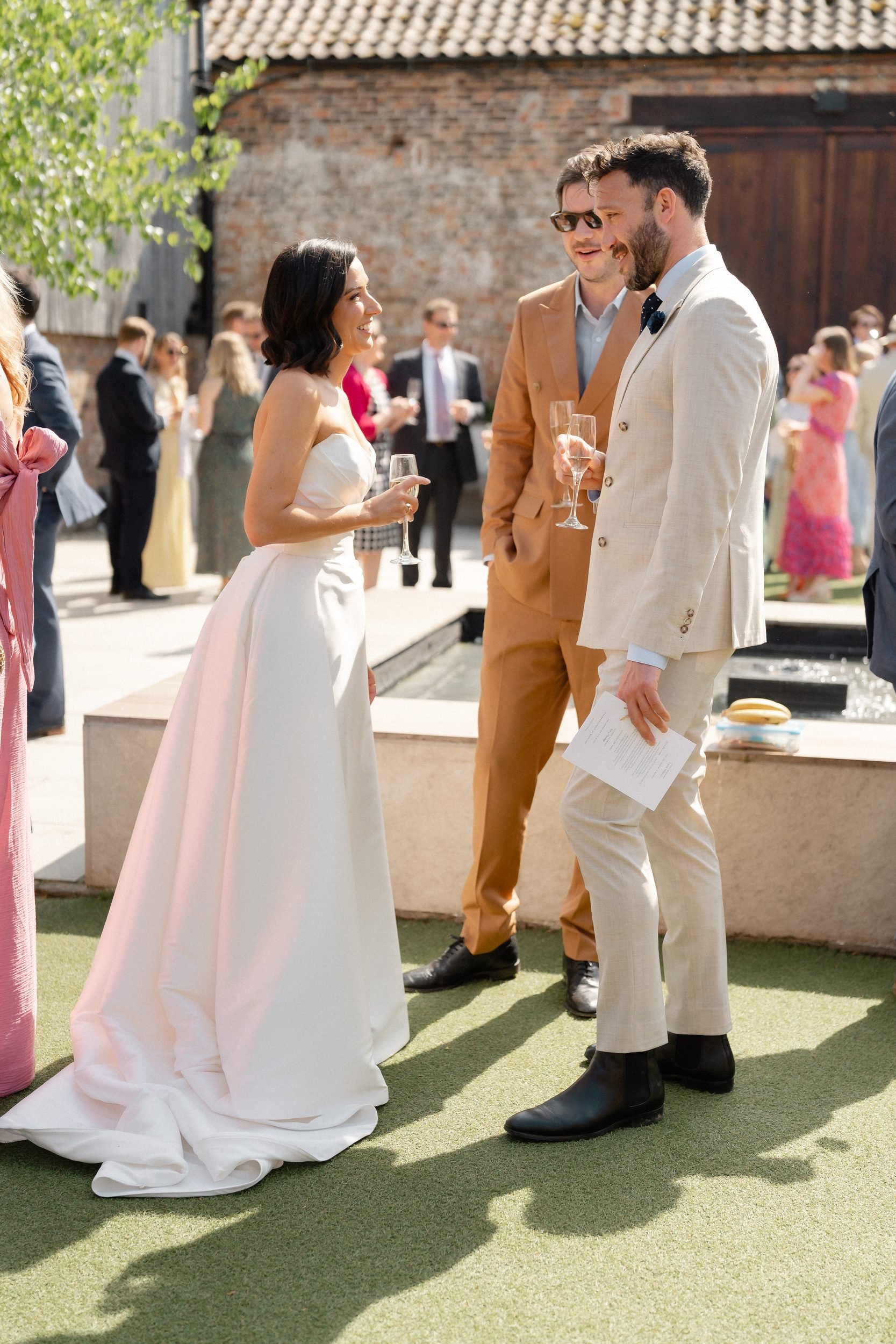 bride-chatting-guests-courtyard-lawn-summer-wedding-401.jpg
