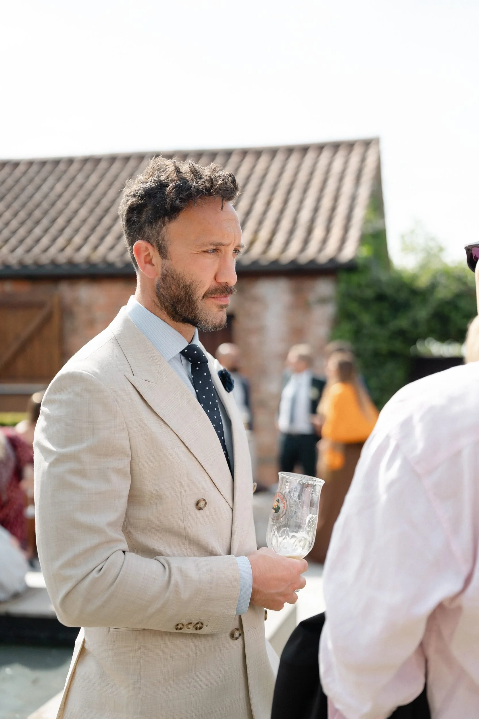 guest-cream-suit-drinks-reception-farm-courtyard-658.jpg