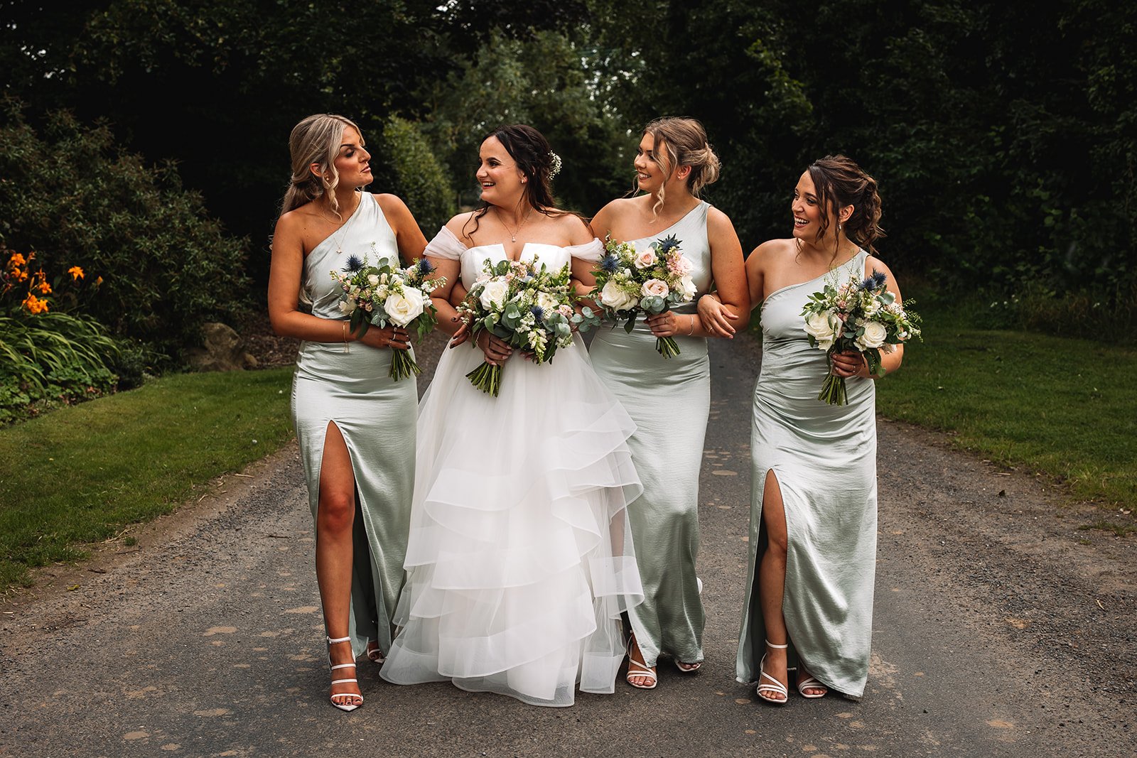 Bride with bridesmaids outside The Normans wedding venue. Photo by Lumiere