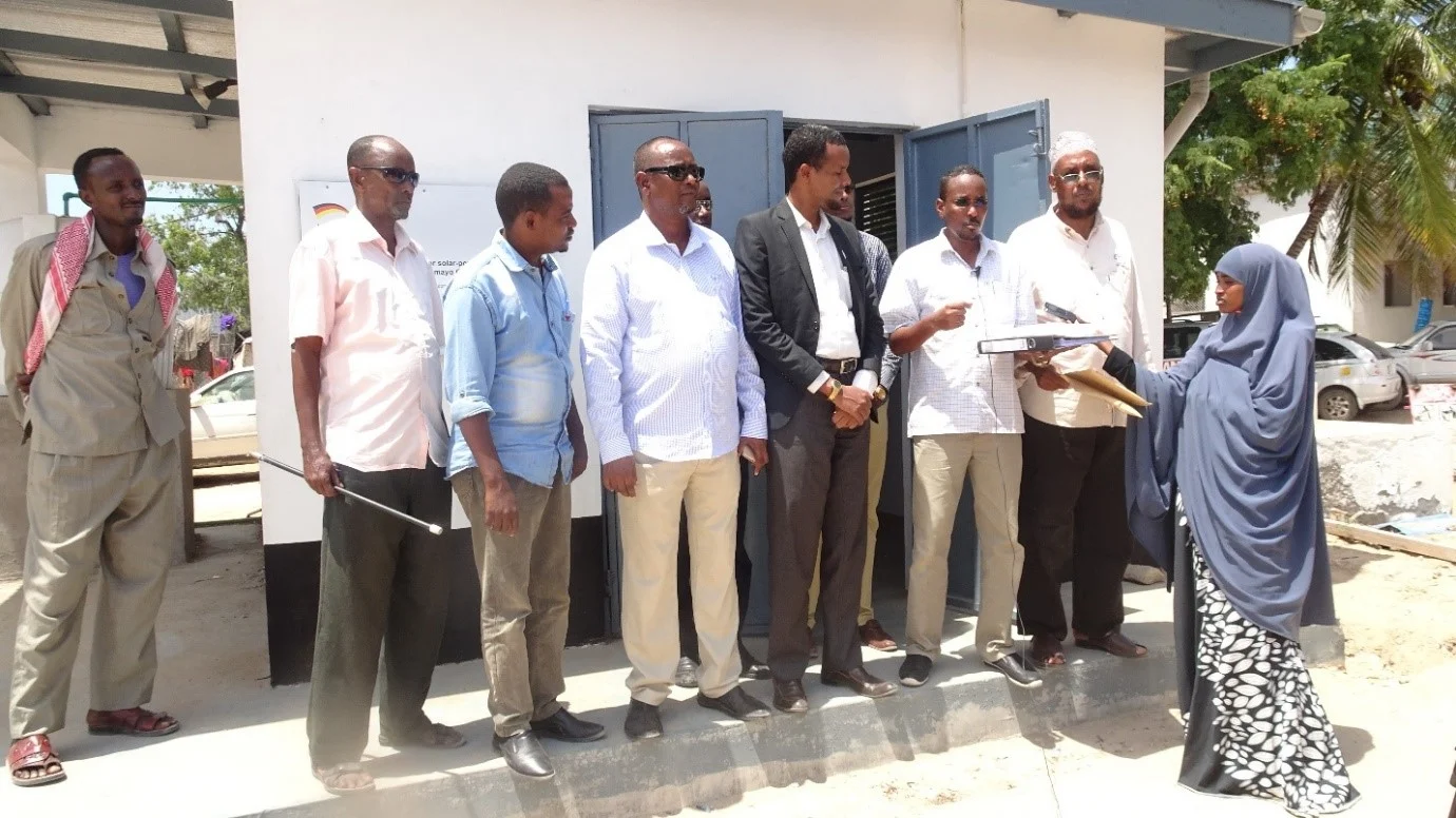 Mr Sirat, the GIZ coordinator, presents the desalination plant manuals to Mr. Ali Noor, Minister for Health for Jubaland State, Somalia.