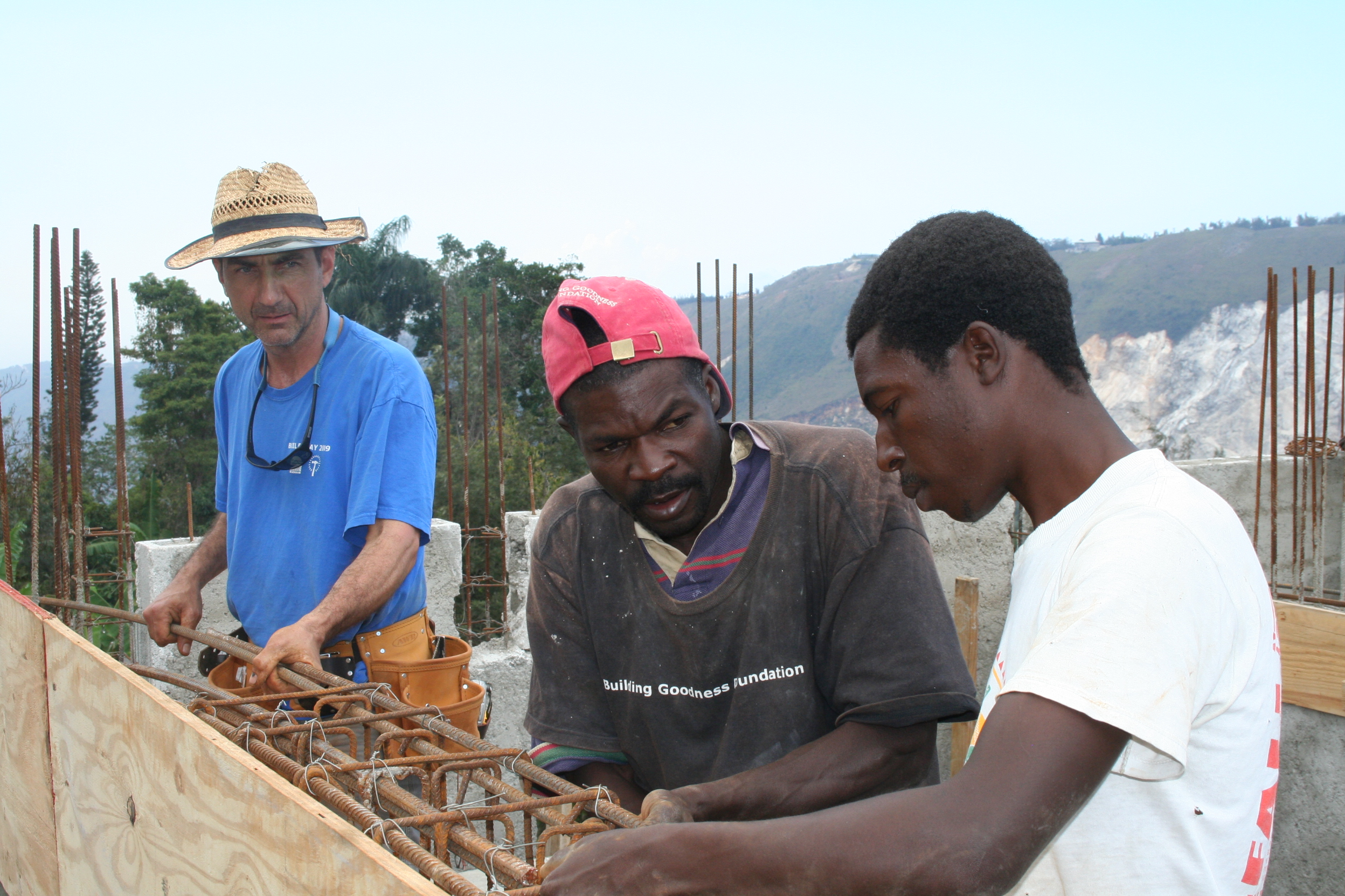 American and Haitian laborers working side-by side to prepare the reinforcing for a concrete wall pour. 