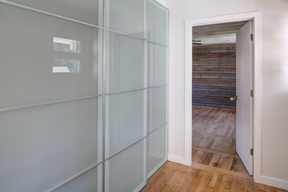 Rolling glass panels conceal the laundry area and coat closet.