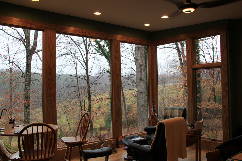 The bedroom sitting area offers tranquil views through the forest to nearby fields and ridgelines