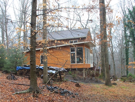 The forest canopy, in combination with the deep overhanging eave, minimize the solar heat gain through the large expanses fo glass. 