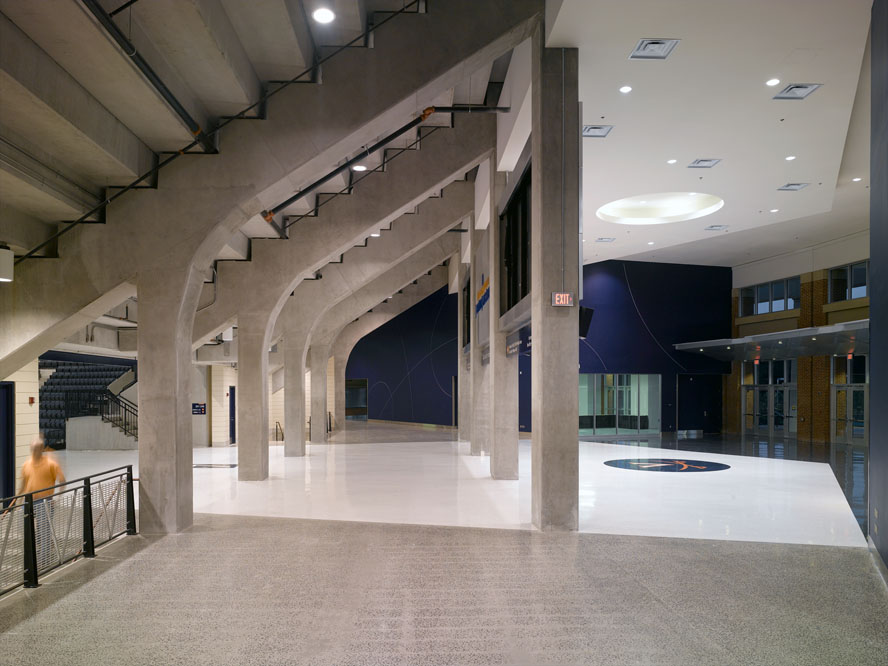 The Cavaliers' dark blue color palette complements the exposed reinforced concrete of the seating bowl's structural system. 