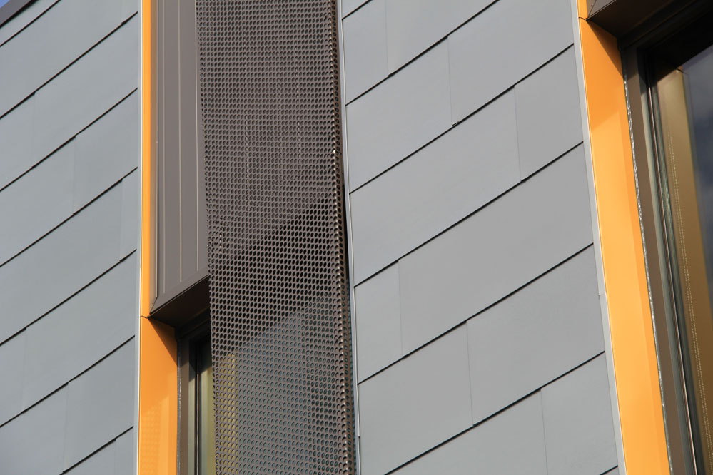 Perforated steel sunshades animate openings in the south-facing office block.