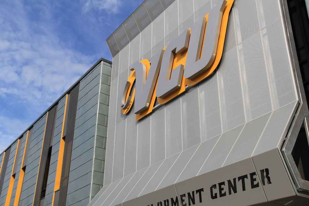 A perforated aluminum screen, highlighted by the VCU logo, shades the south-facing glass of the lobby. 