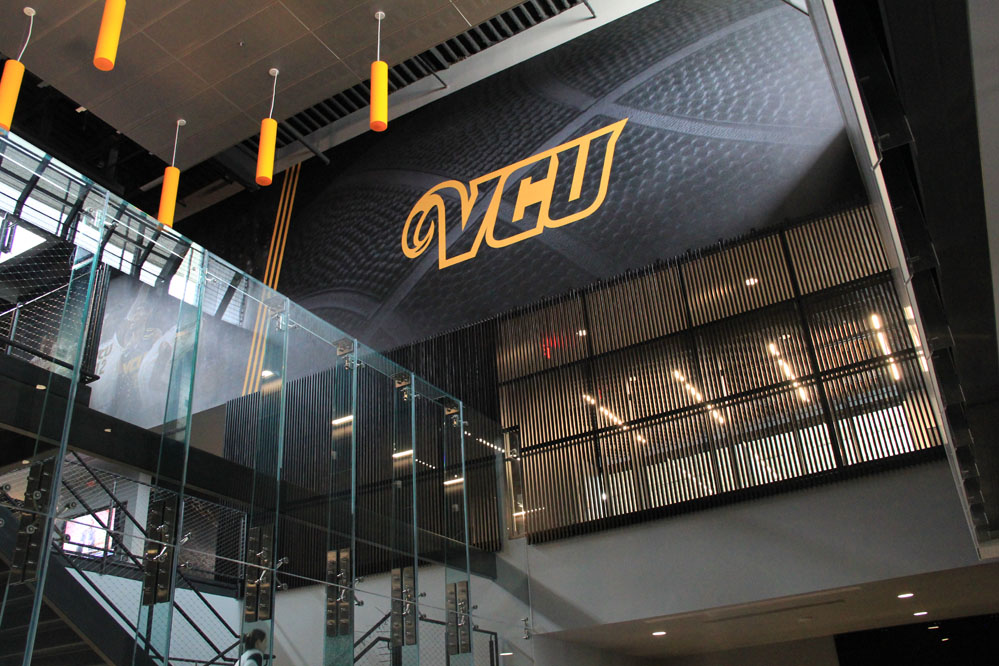 Clerestories provide abundant light to the rich palette of steel, glass, and wood in the building lobby.  Large-format graphics reinforce the VCU brand throughout the facility.