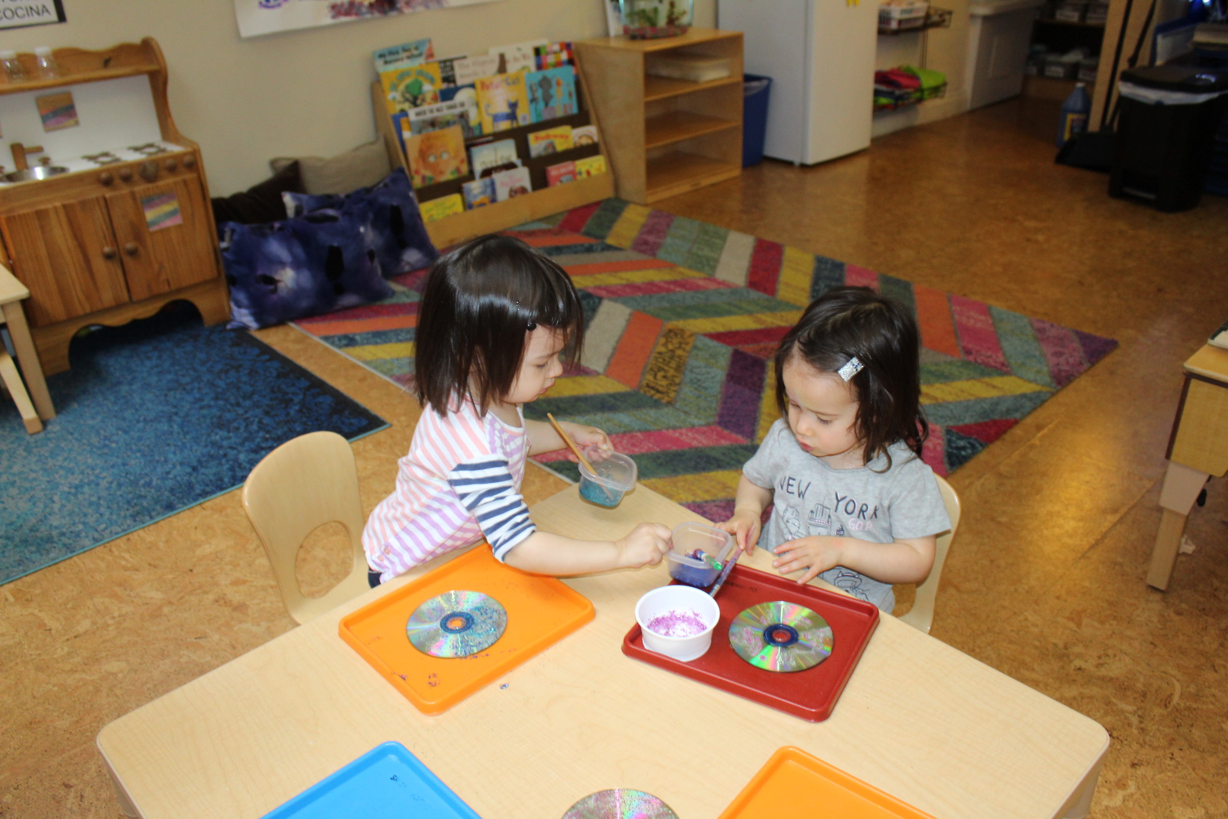    Some children were creating suncatchers by adorning CDs.&nbsp; They used glitter, glue, and sequins. Each step enhances their cognitive ability, as they think about their choices.&nbsp; They selected two different colors of glitter and mixed each