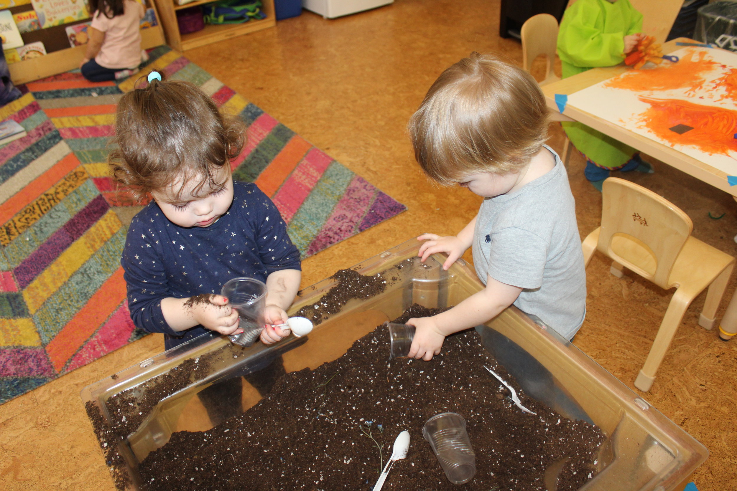  The children were excited to explore soil! The soil is one of the natural element for planting. They squeezed, touched,  and clutched some in their hands to pour it into a cup. They scooped and emptied small cups. We also included some props in the 