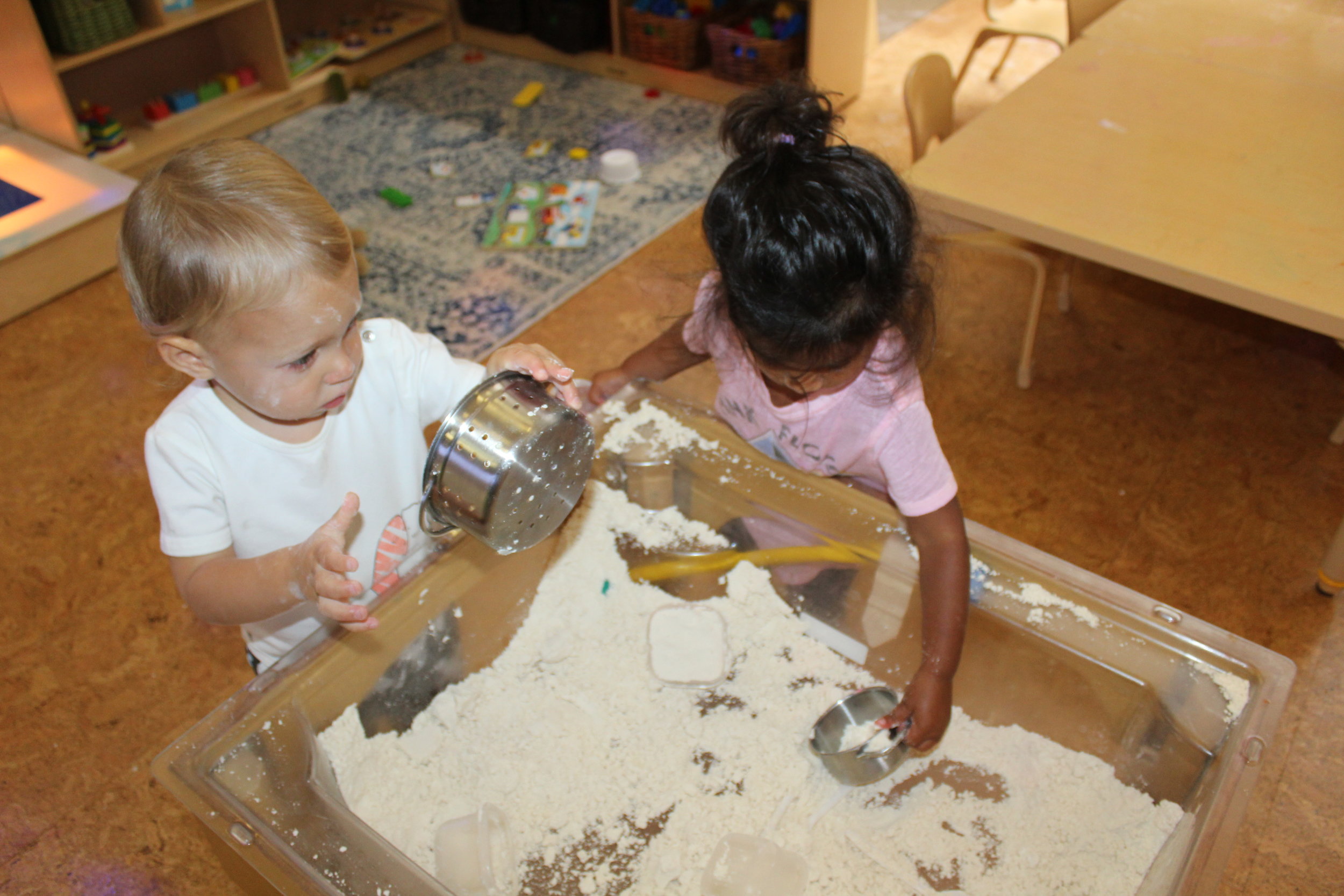  The teacher put flour and baby oil mix in the sensory table for the students to explore this stimulus material, “Cloud Dough.” Some children appeared hesitant to engage and investigate. But gradually the little hands and fingers delved into the soft