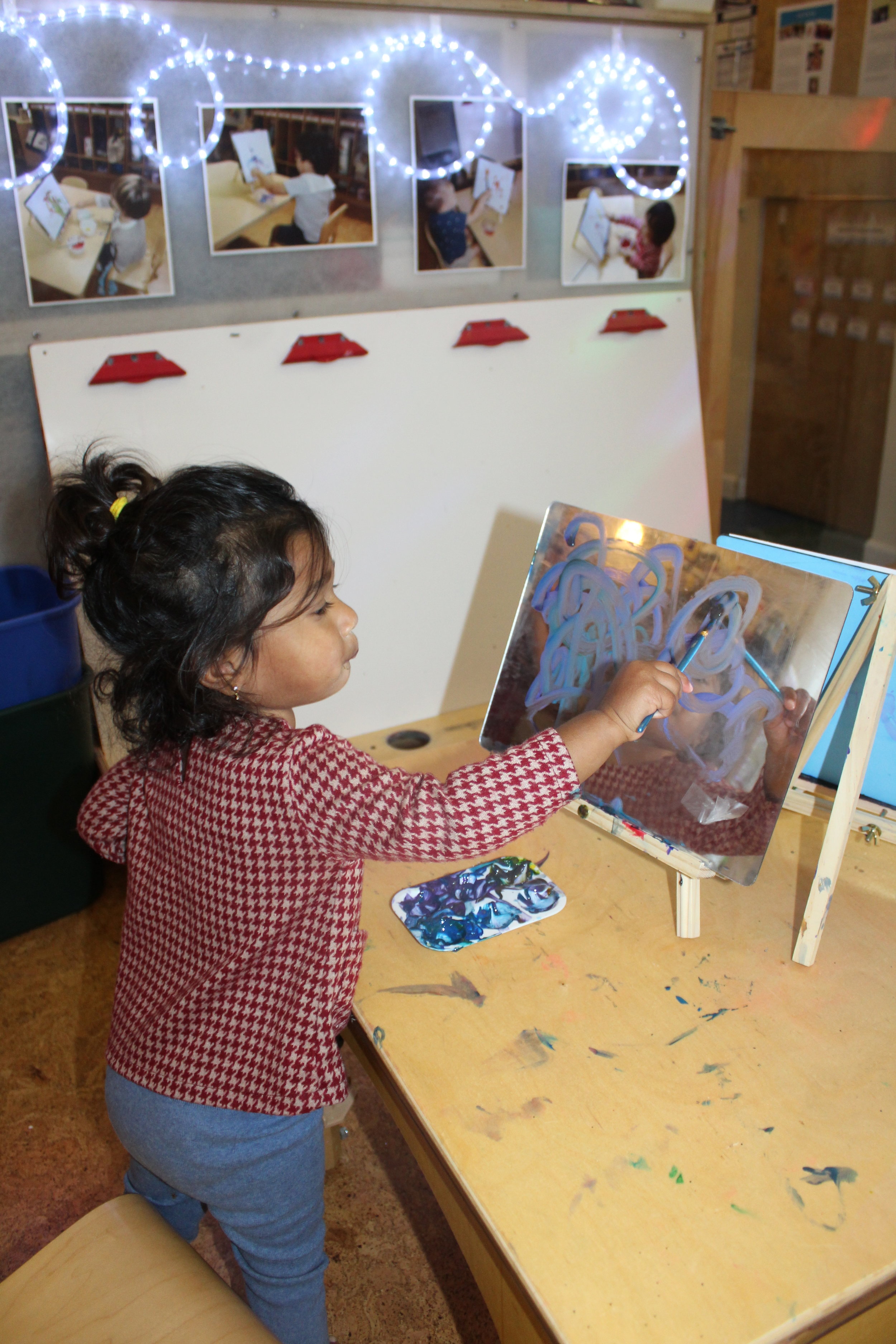  The teacher was going to place a paper on the easel; however, she noticed how Leela was painting on the mirror with the paintbrush. This open-ended art activity is all about the process. The concept “Process Art” applies to young children because it