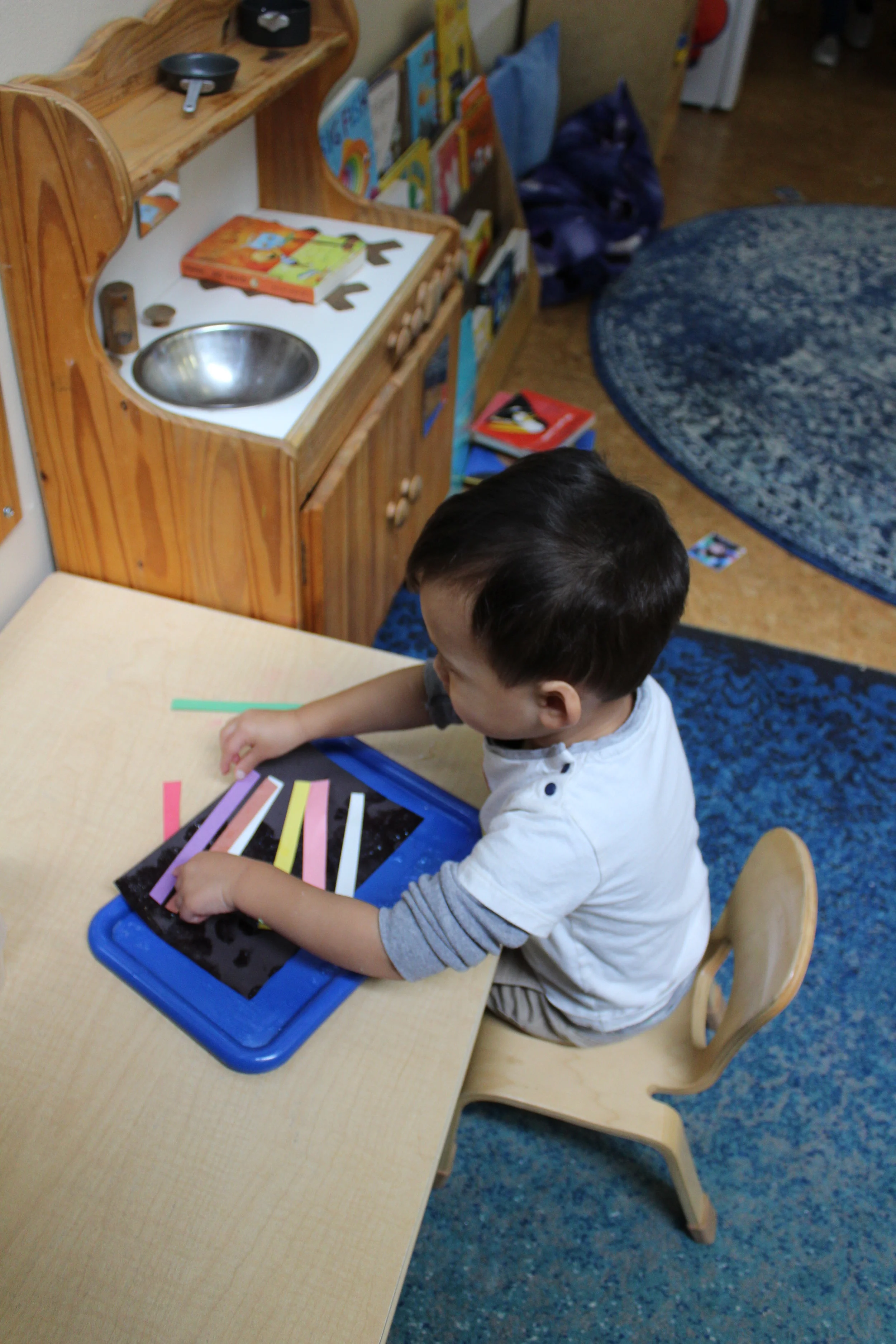  We are exploring colors and lines. The children applied glue on black construction paper and placed one, two, three or more color strips on their paper. Their lines went horizontal, vertically,  and parallel. Every arrangement is distinctive and uni