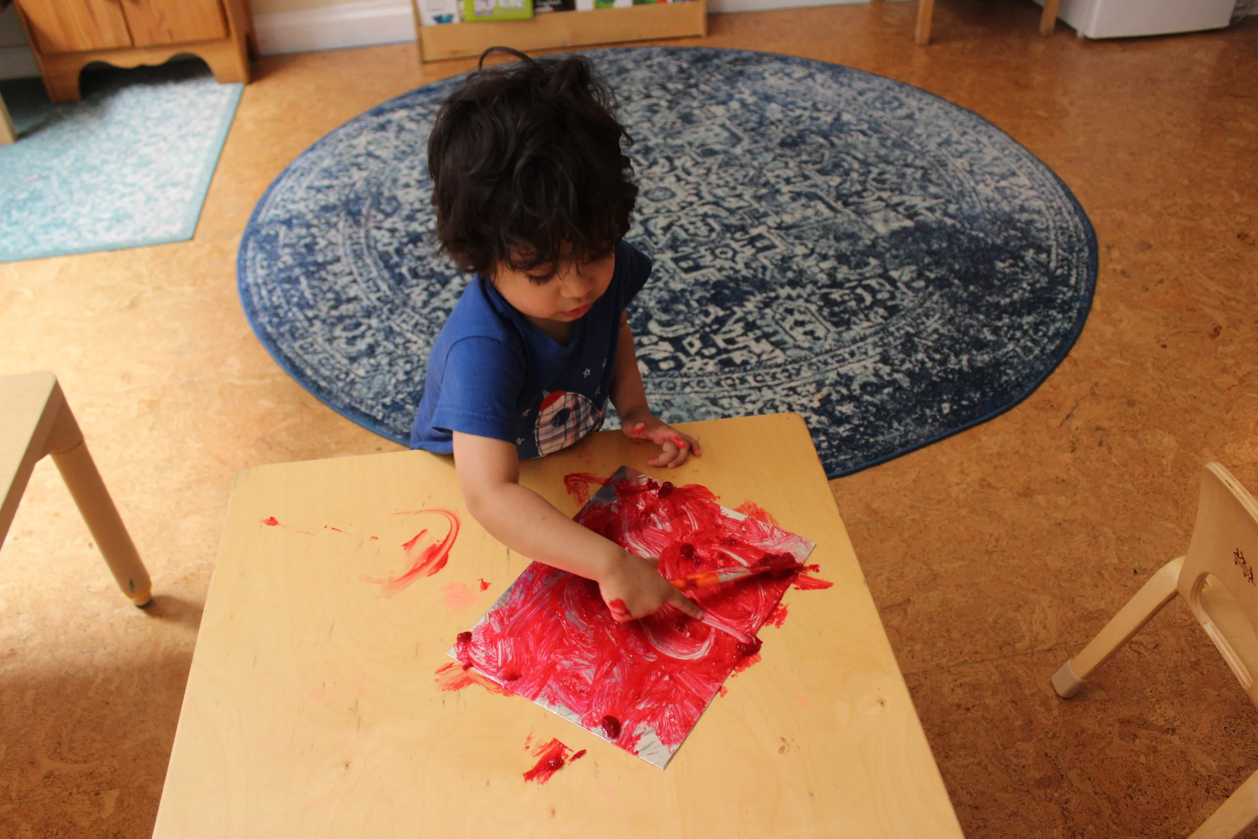  Rohan is painting with his hands, paintbrush, and the opposite side of the paintbrush he indicated, "I'm drawing!"&nbsp; He used three different techniques to explore painting on foil paper.&nbsp;&nbsp;   