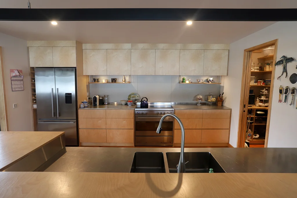 Contemporary kitchen with oiled birch plywood and plate stainless benchtops