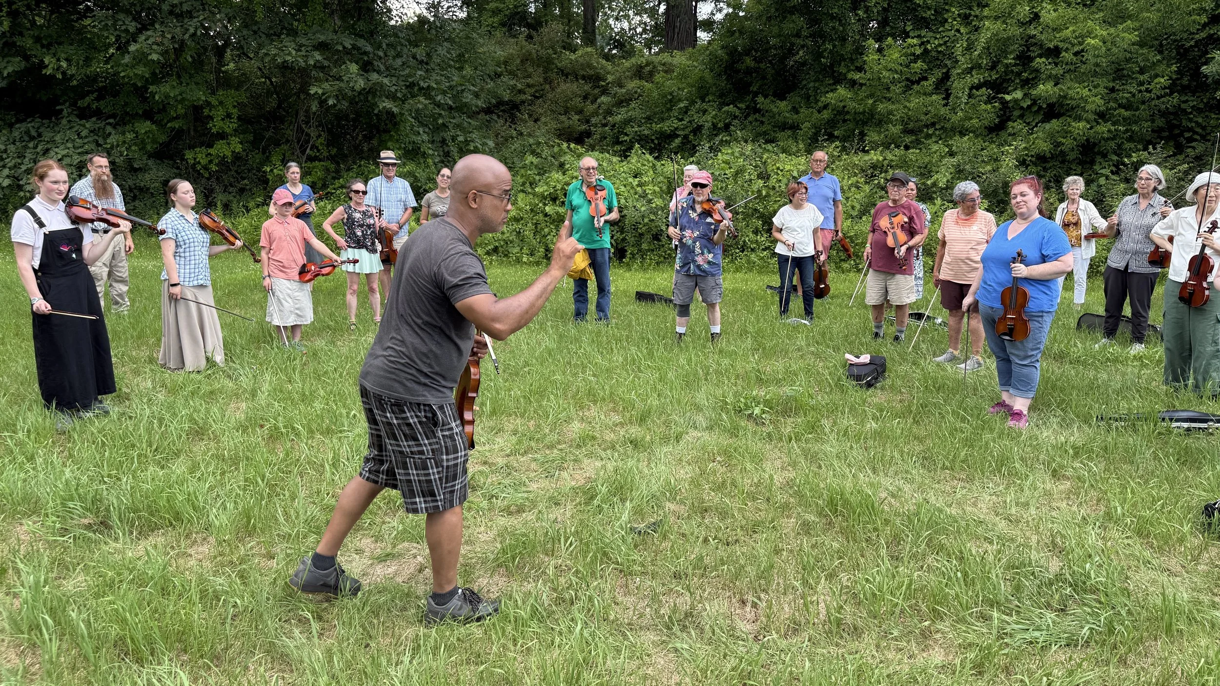 Composer Daniel Bernard Roumain leads a violin workshop to integrate audience members with the premiere of his newest work in Schuylerville, NY on July 6, 2025
