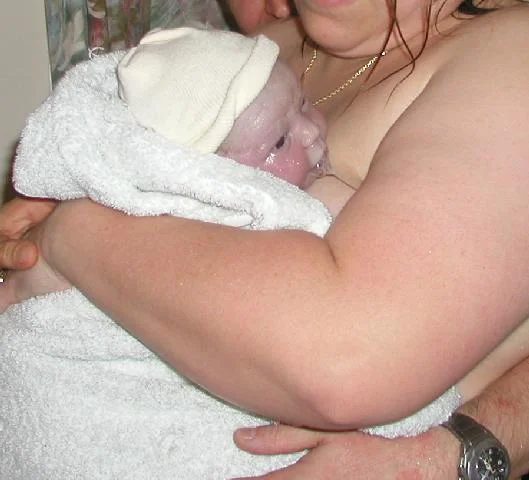5:08 am Julia is immediately placed in my arms (still a little goopy). Mike supports me. I think she's a boy ... silly umbilical cord!