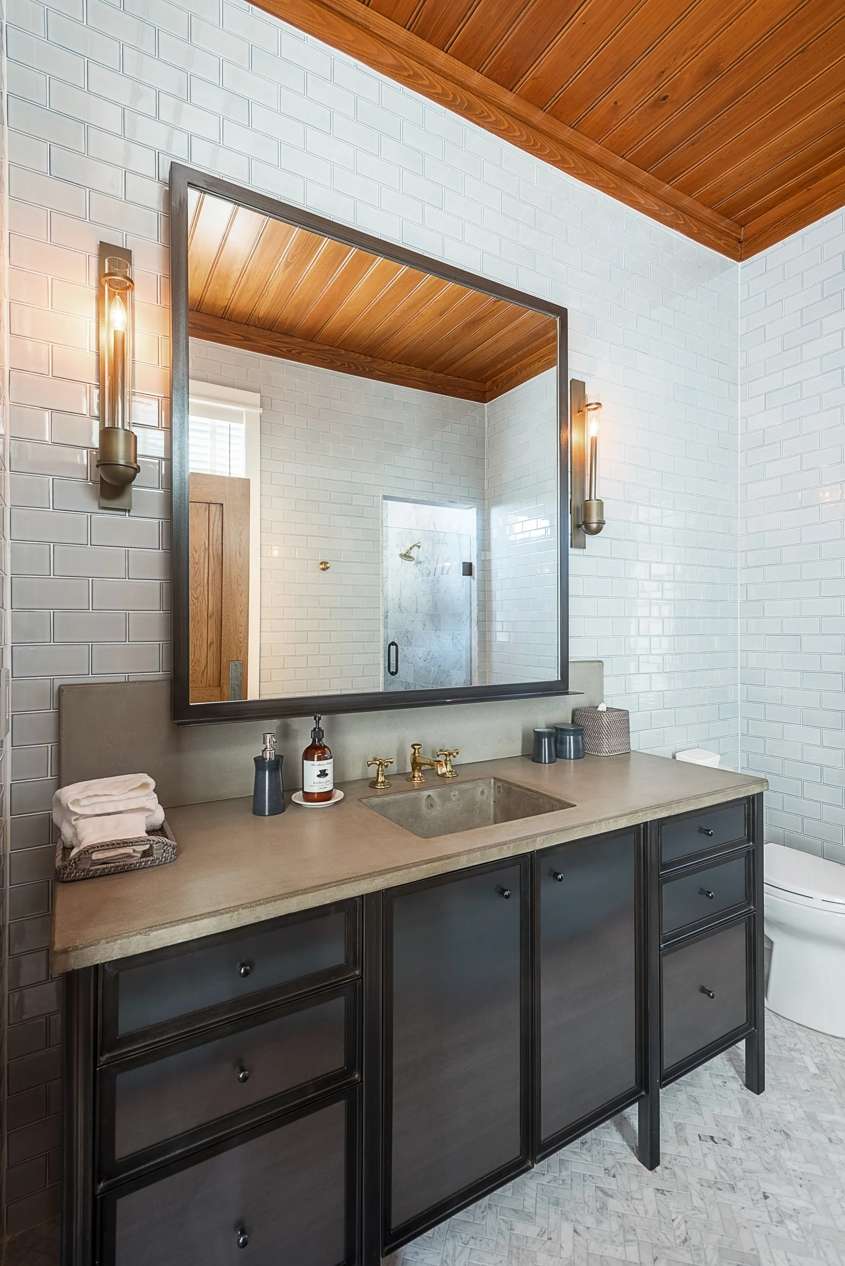 Interior photography of bathroom vanity, custom built with steel cabinetry fronts and concrete counter top.