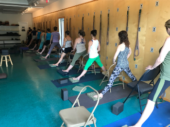 Pressing down on chair to lift from the kidneys in Parsva Padasana