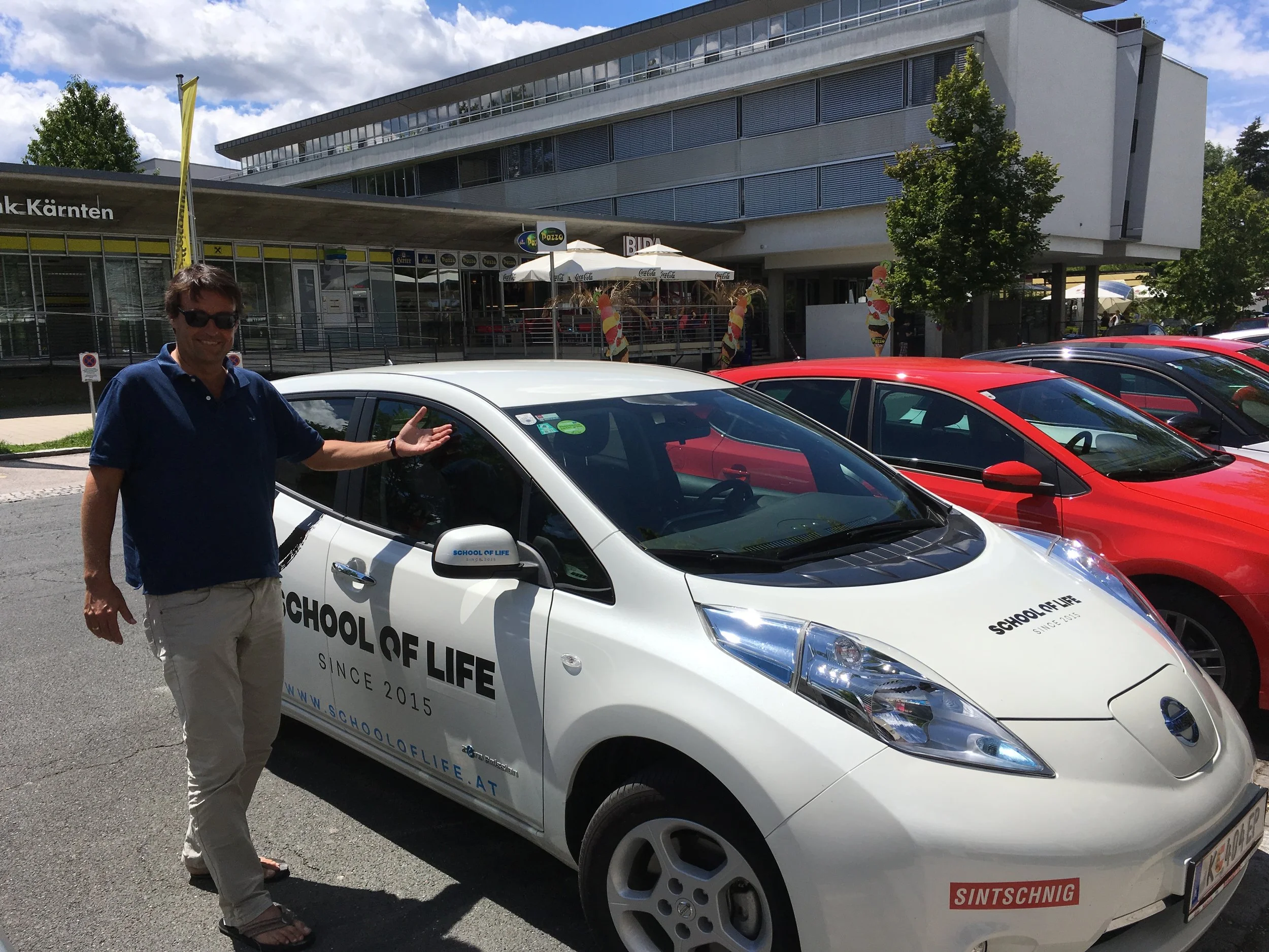 Mag. Werner Sattlegger, Director School of Life mit dem Elektroauto, powered by Motodrom Sintschnig