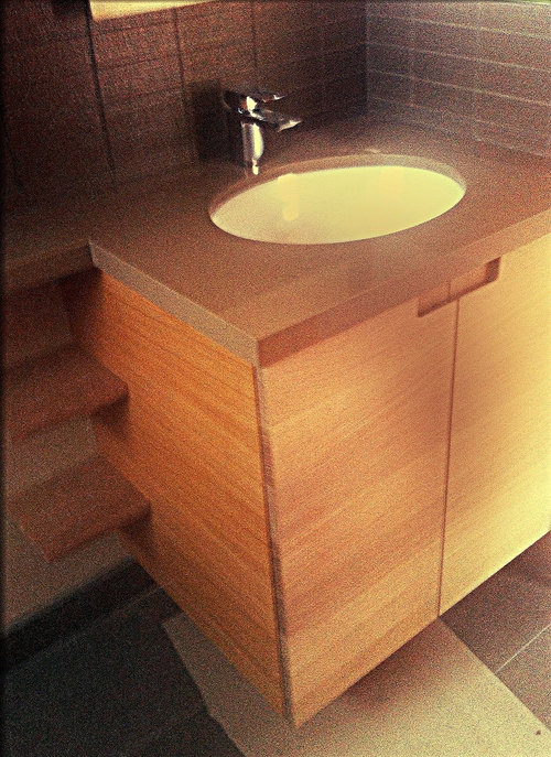 Custom floating vanity with integrated pulls and shelving