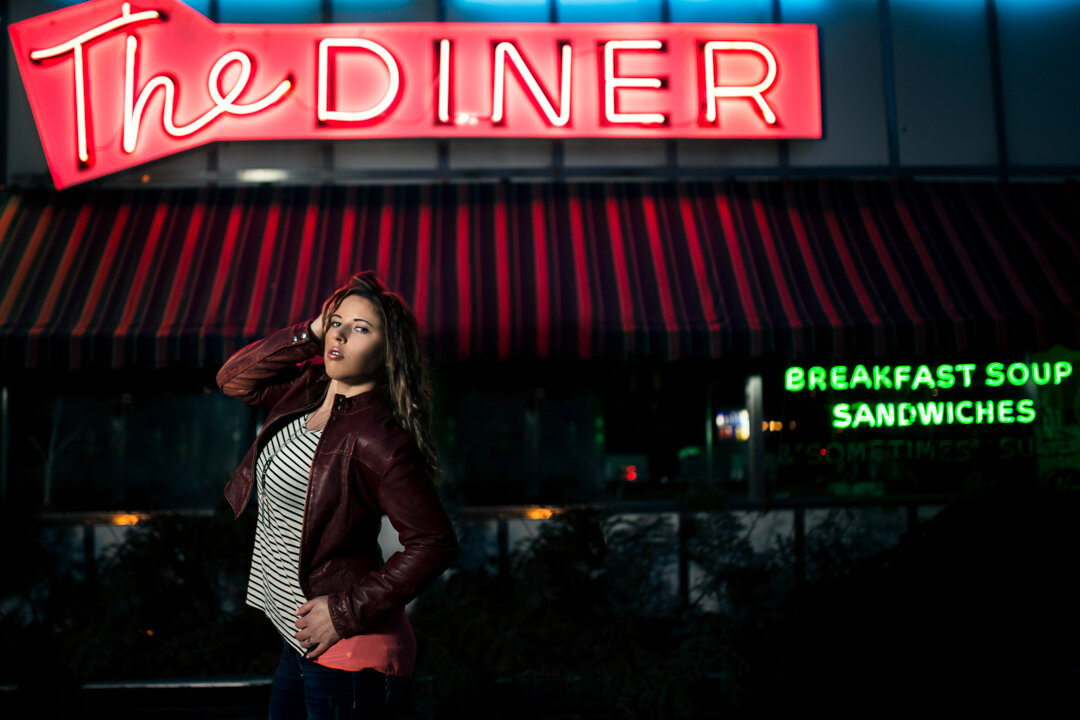 high school photo in Omaha in front of neon sign